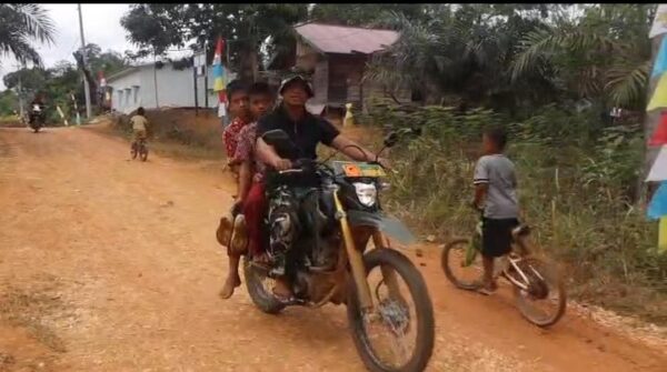 Kepedulian Anggota Satgas TMMD, Mengantar Siswa ke Sekolah Karena Kondisi Jalan Yang Memprihatinkan