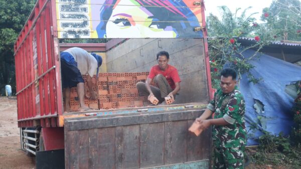 Bersama Warga, Anggota Satgas TMMD ke-128 Goro Turunkan Bata 