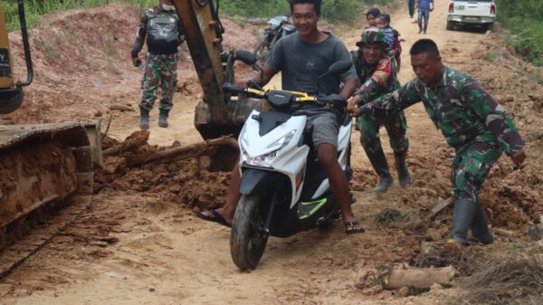 Sigap, Anggota Satgas TMMD ke 128 Kodim 0420/Sarko Bantu Warga Kesulitan Melintas di Jalan Rusak