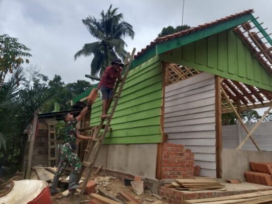 Kebersamaan TNI dan Warga, Koptu Gunawan dan Bapak Wanto Pasang Genteng RTLH Milik Bapak Ruslan